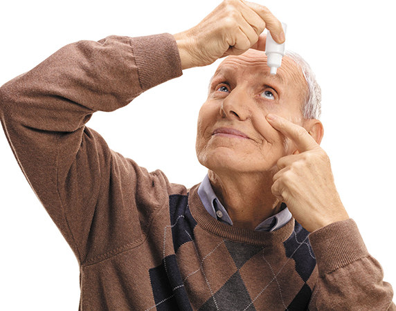 Man putting eye drops in eye