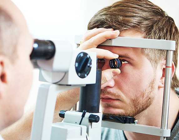Eye doctor performing eye exam on patient